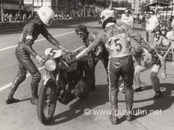 Gary Green & Dave Potter changing over, while Dave Sleat holds the bike and Vincent Davey inspects the rear tyre.